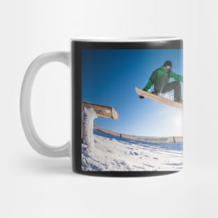 Snowboarder jumping against blue sky Mug